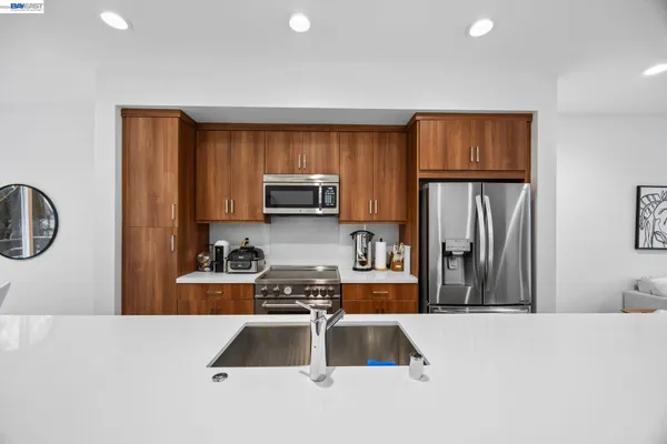 a kitchen with stainless steel appliances granite countertop a refrigerator a stove top oven a sink and dishwasher