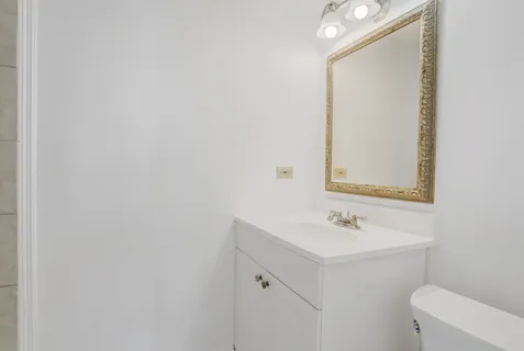 a bathroom with a sink mirror and toilet