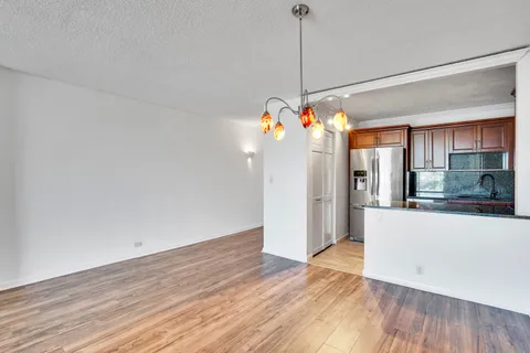 a view of a room with wooden floor and chandelier