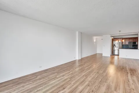 a view of a big room with wooden floor and windows