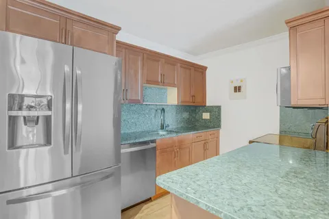 a kitchen with stainless steel appliances granite countertop a refrigerator and a sink