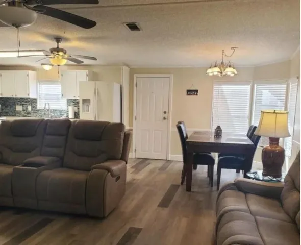 a living room with furniture a chandelier and a large window