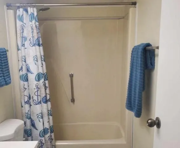a bathroom with a shower curtain and a toilet