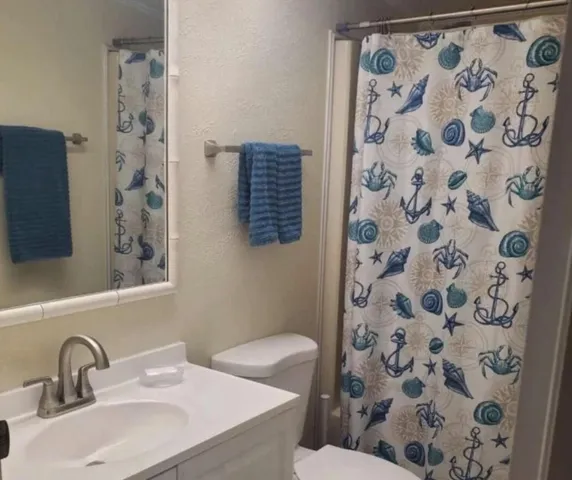 a bathroom with a sink and mirror with toilet