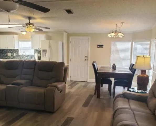 a living room with furniture a chandelier and a flat screen tv