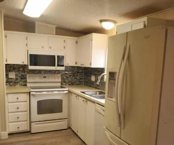 a kitchen with stainless steel appliances a refrigerator sink and microwave