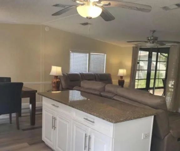 a living room with kitchen island furniture and a chandelier