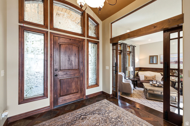 335 Bern Way Midway, UT 84049 - Photo 9 of 88 Foyer featuring a paneled wood entry door with arched transom and sidelight windows, dark wood-finish flooring, and a cased opening with sliding wood and glass doors
