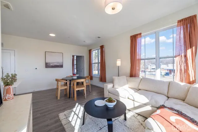 a living room with furniture a rug and a large window