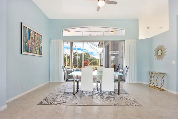 a dining room with wooden floor and large windows