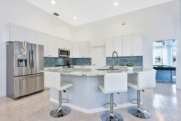 a kitchen with stainless steel appliances granite countertop a sink and a refrigerator