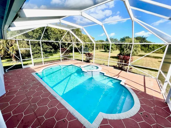 a view of a house with a big yard and palm trees