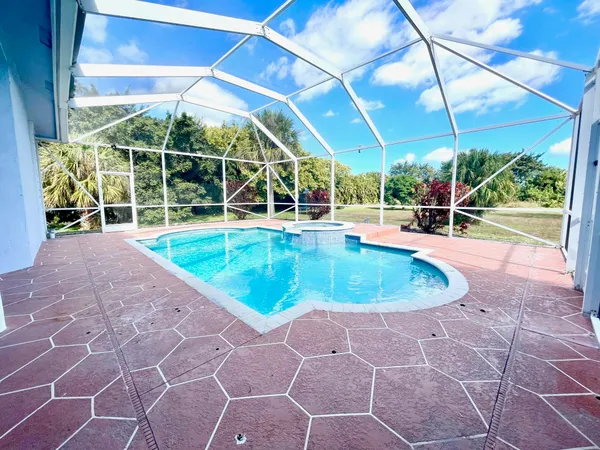 a view of a garden with an tree and wooden fence