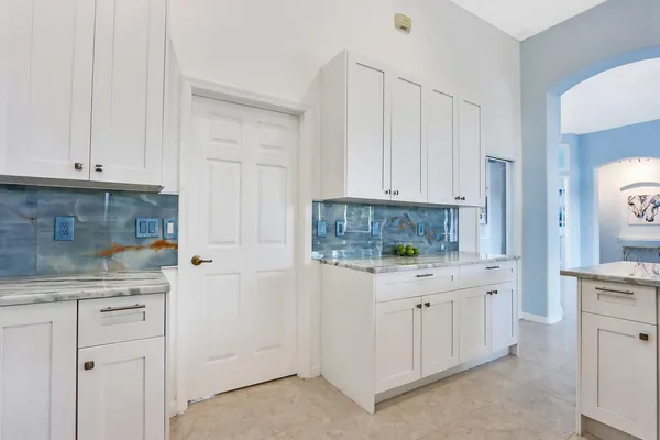 a kitchen with white cabinets and white appliances