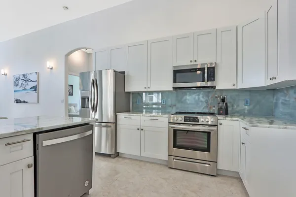 a kitchen with white cabinets and stainless steel appliances