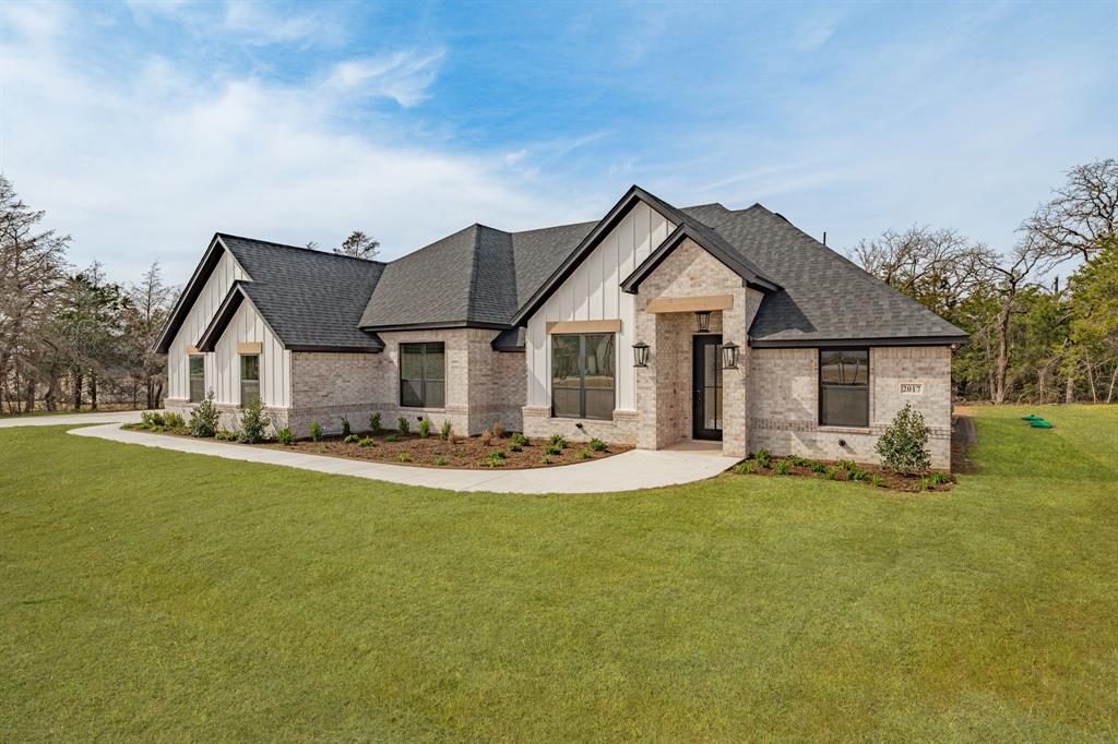 2017 Forest Bridge Azle, TX 76020 - Photo 2 of 30 View of front of house featuring board and batten siding, a front lawn, brick siding, and roof with shingles