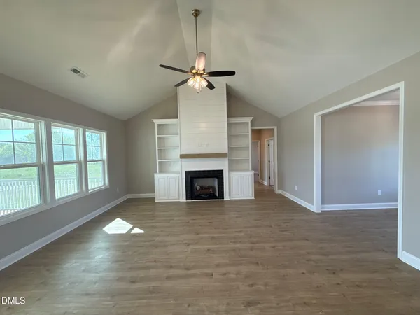 a view of an empty room with wooden floor and entryway