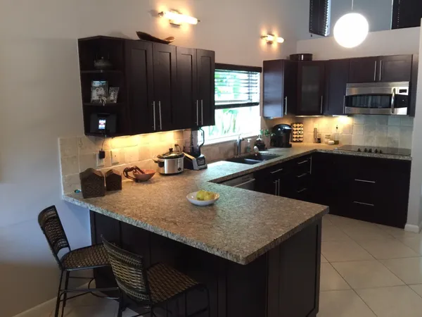 a kitchen with a sink a kitchen island wooden cabinets and stainless steel appliances