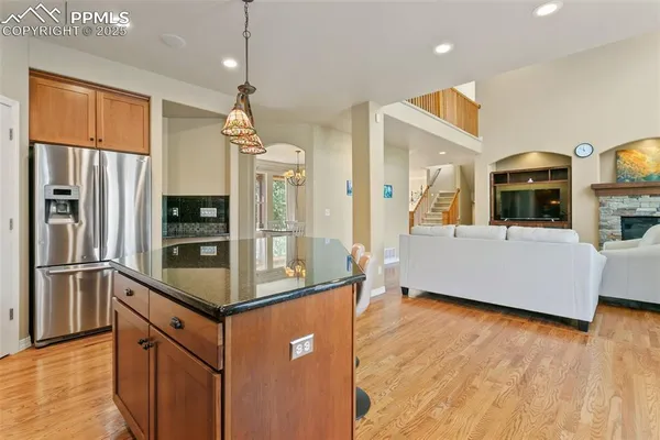 a kitchen with stainless steel appliances kitchen island granite countertop a refrigerator and a stove top oven