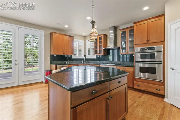 a kitchen with stainless steel appliances granite countertop a sink a stove and a refrigerator
