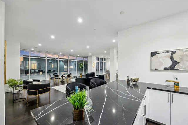 a large white kitchen with stainless steel appliances a sink and a large window