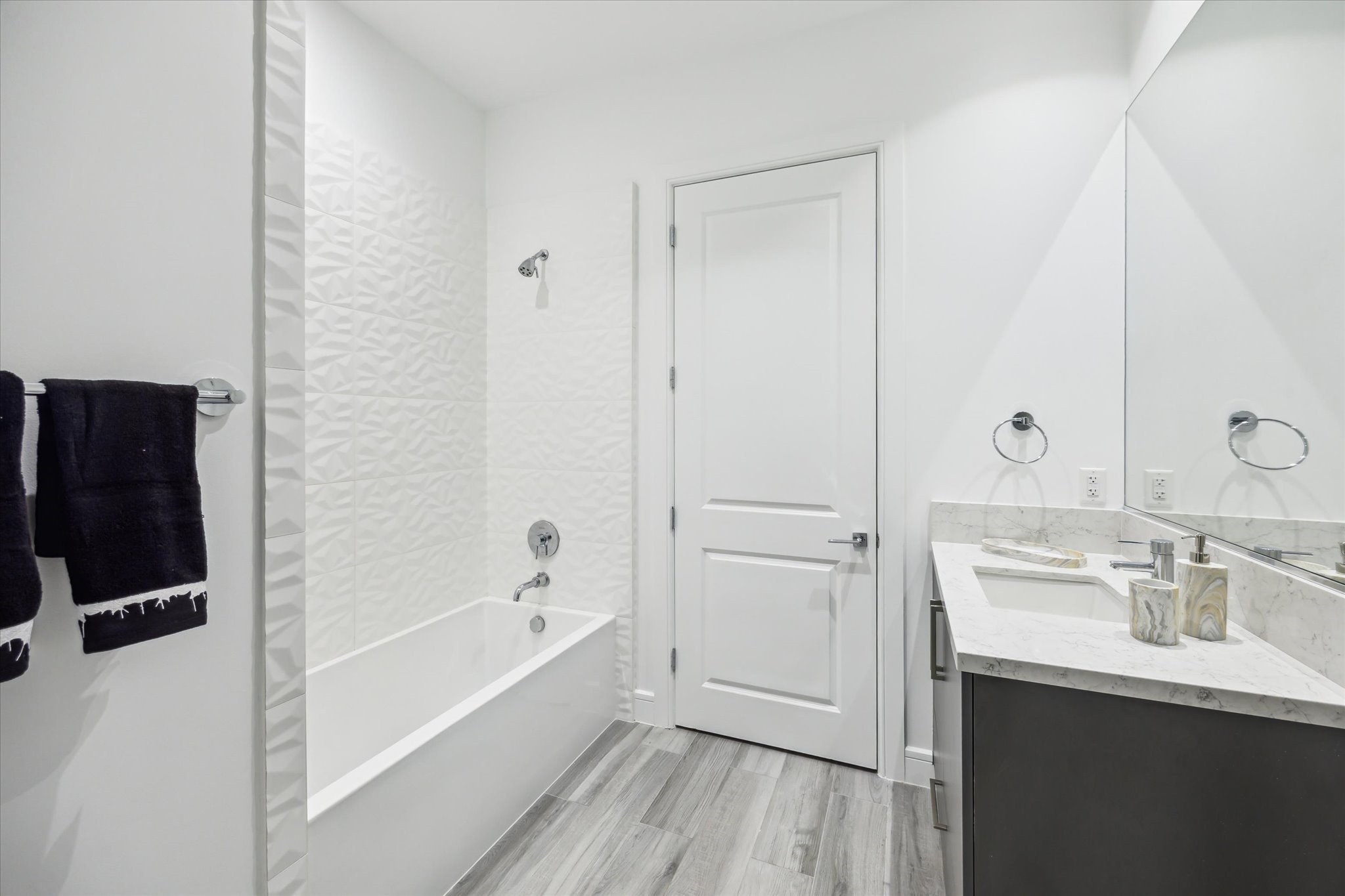4521 San Felipe Street, Unit 23045 Houston, TX 77027 - Photo 24 of 25 a bathroom with a bathtub a sink a vanity and a shower