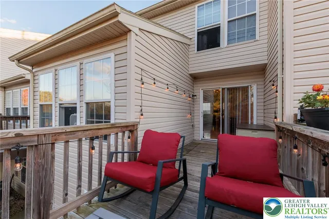 a red brick house with red chairs in front of it