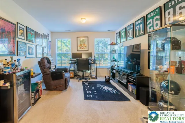a living room with furniture a flat screen tv and a window
