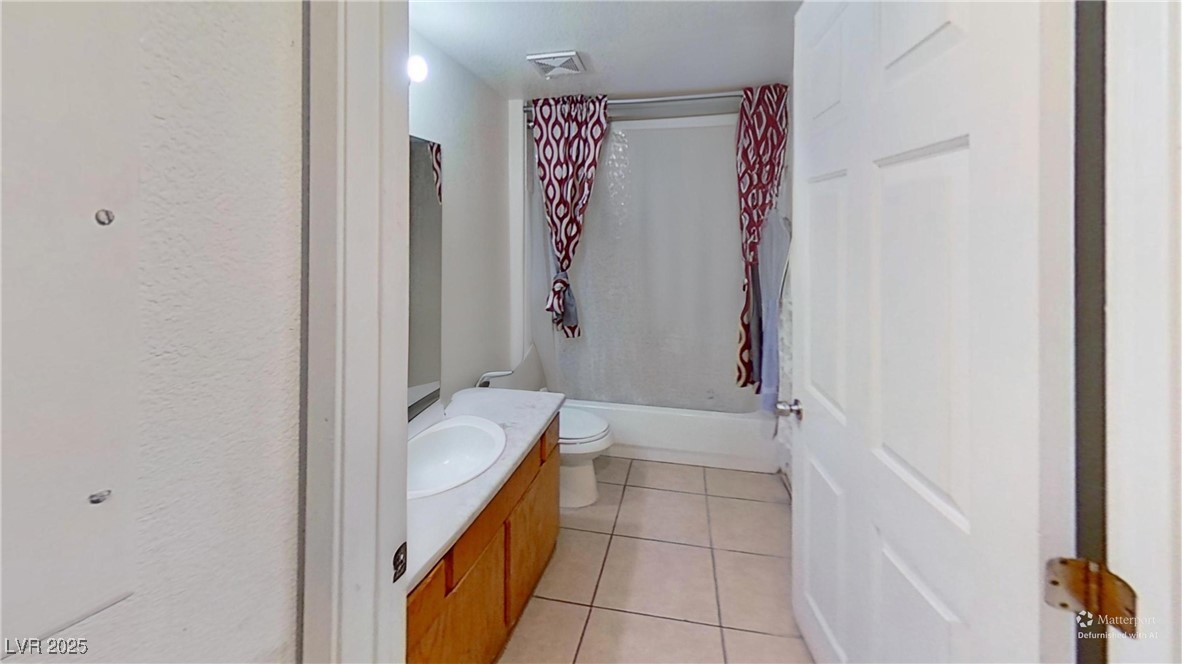2201 James Bilbray Drive Las Vegas, NV 89108 - Photo 25 of 33 Bathroom featuring light tile patterned flooring, vanity, and shower / tub combo