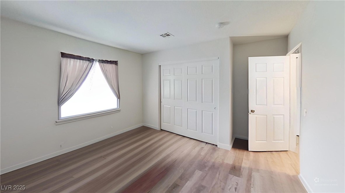2201 James Bilbray Drive Las Vegas, NV 89108 - Photo 28 of 33 Unfurnished bedroom featuring light wood finished floors and a closet