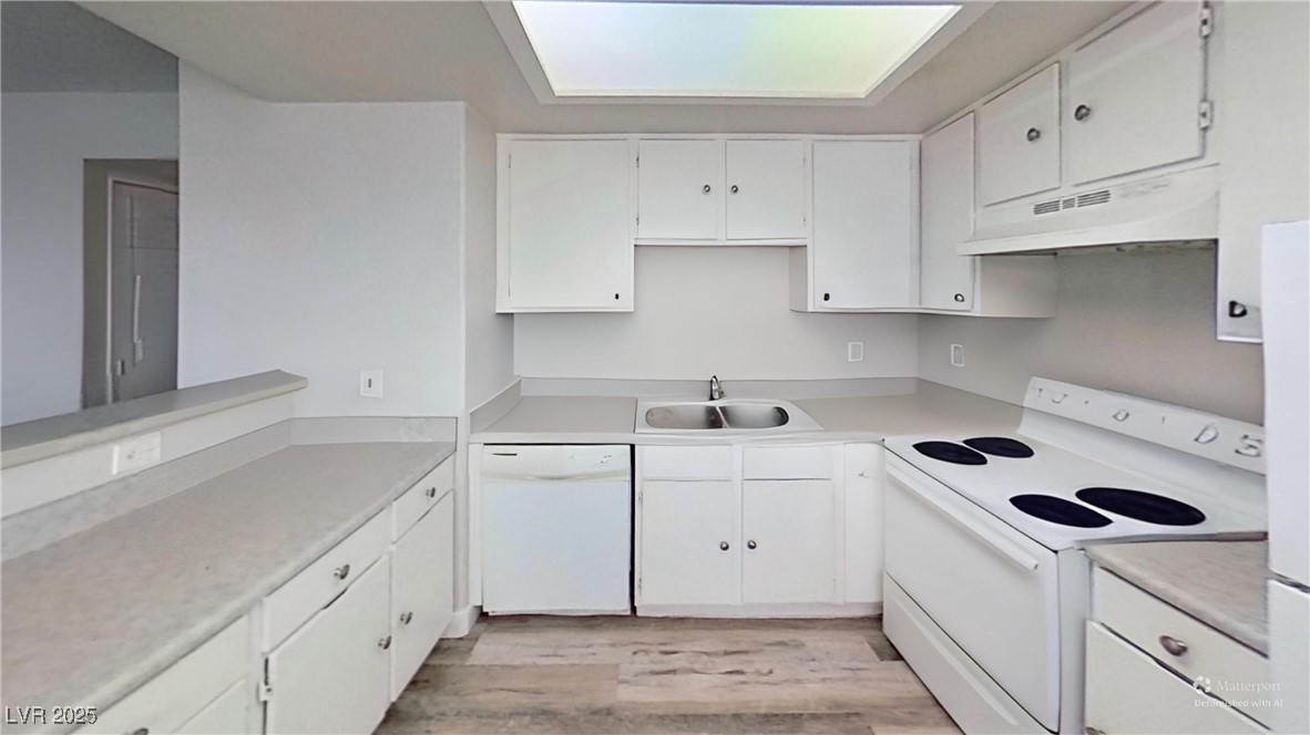 2201 James Bilbray Drive Las Vegas, NV 89108 - Photo 4 of 33 Kitchen with white appliances, white cabinets, light countertops, under cabinet range hood, and light wood finished floors
