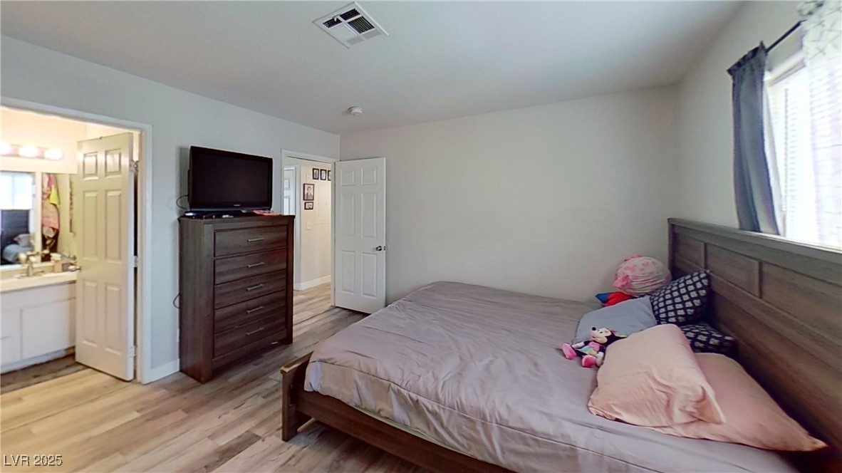 2201 James Bilbray Drive Las Vegas, NV 89108 - Photo 8 of 33 Bedroom with light wood-style floors and baseboards