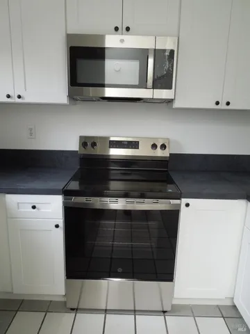 a kitchen with stainless steel appliances granite countertop a stove and a microwave