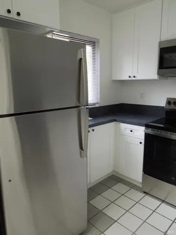 a kitchen with a refrigerator and a stove top oven