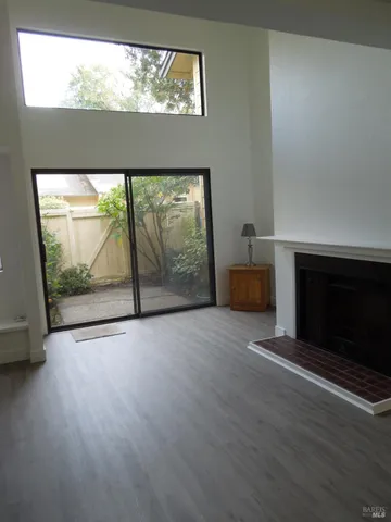 a view of empty room with wooden floor and fireplace