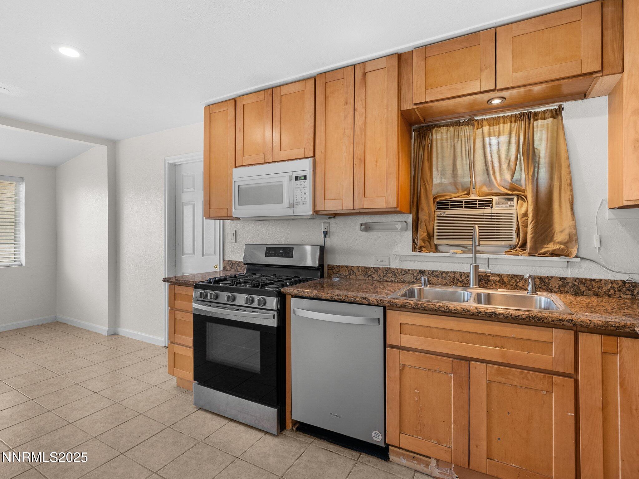 1955 Wilder Street Reno, NV 89512 - Photo 13 of 31 a kitchen with stainless steel appliances granite countertop a sink stove and cabinets
