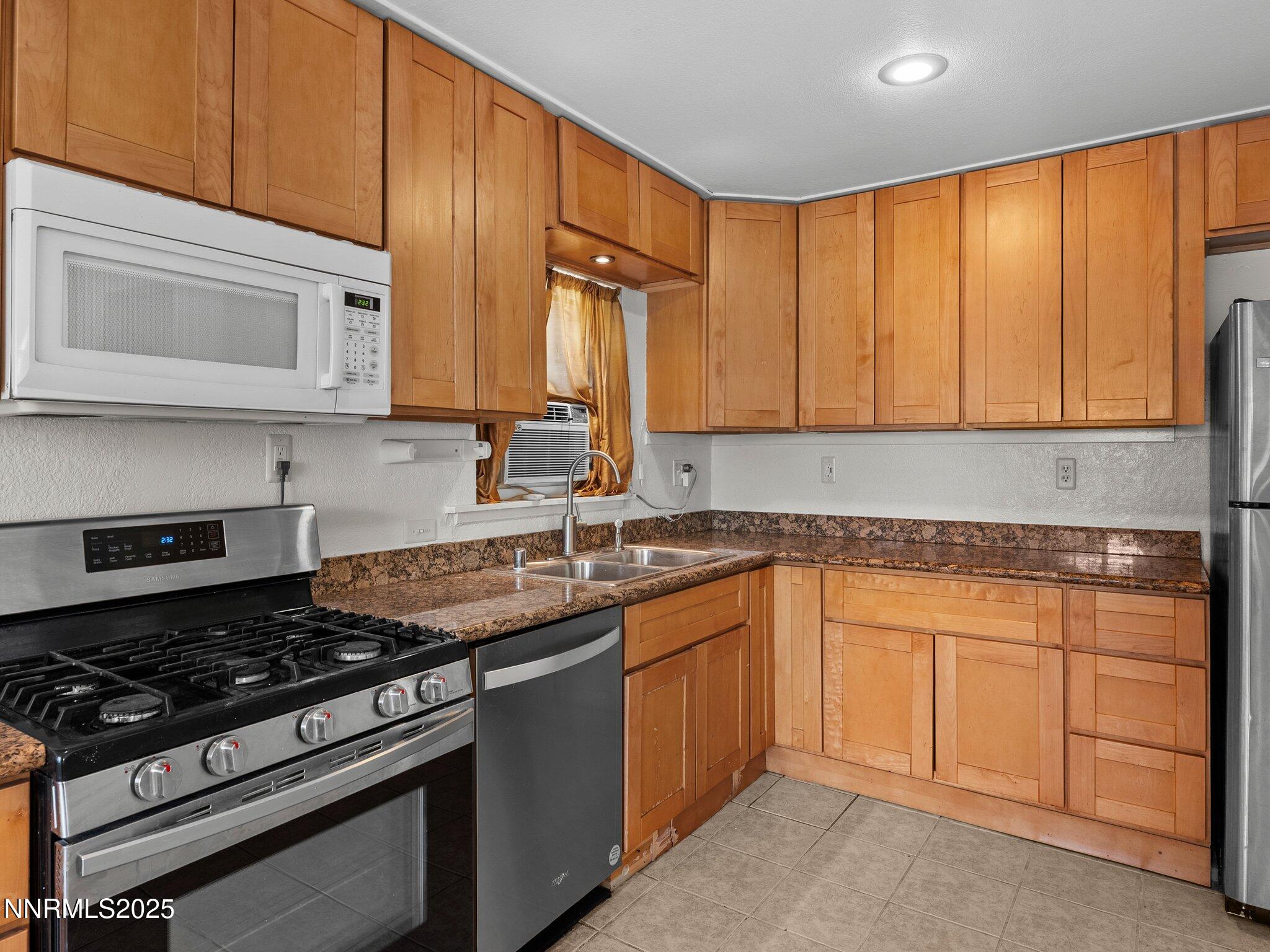 1955 Wilder Street Reno, NV 89512 - Photo 15 of 31 a kitchen with granite countertop wooden cabinets and a stove top oven