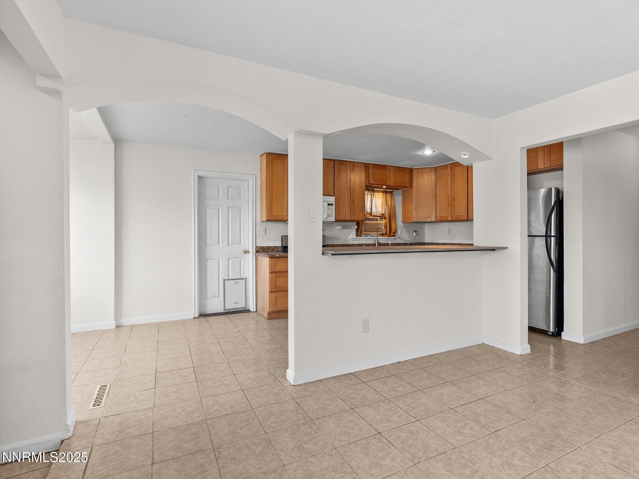 1955 Wilder Street Reno, NV 89512 - Photo 8 of 31 an empty room with a window and a kitchen
