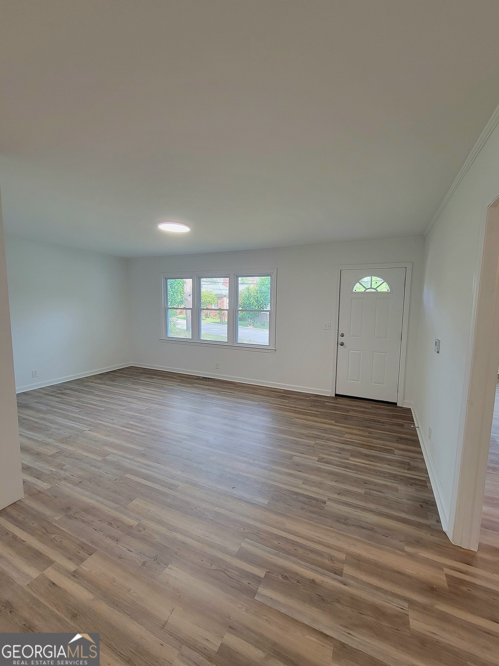 506 East 6th Street West Point, GA 31833 - Photo 4 of 15 an empty room with wooden floor and windows