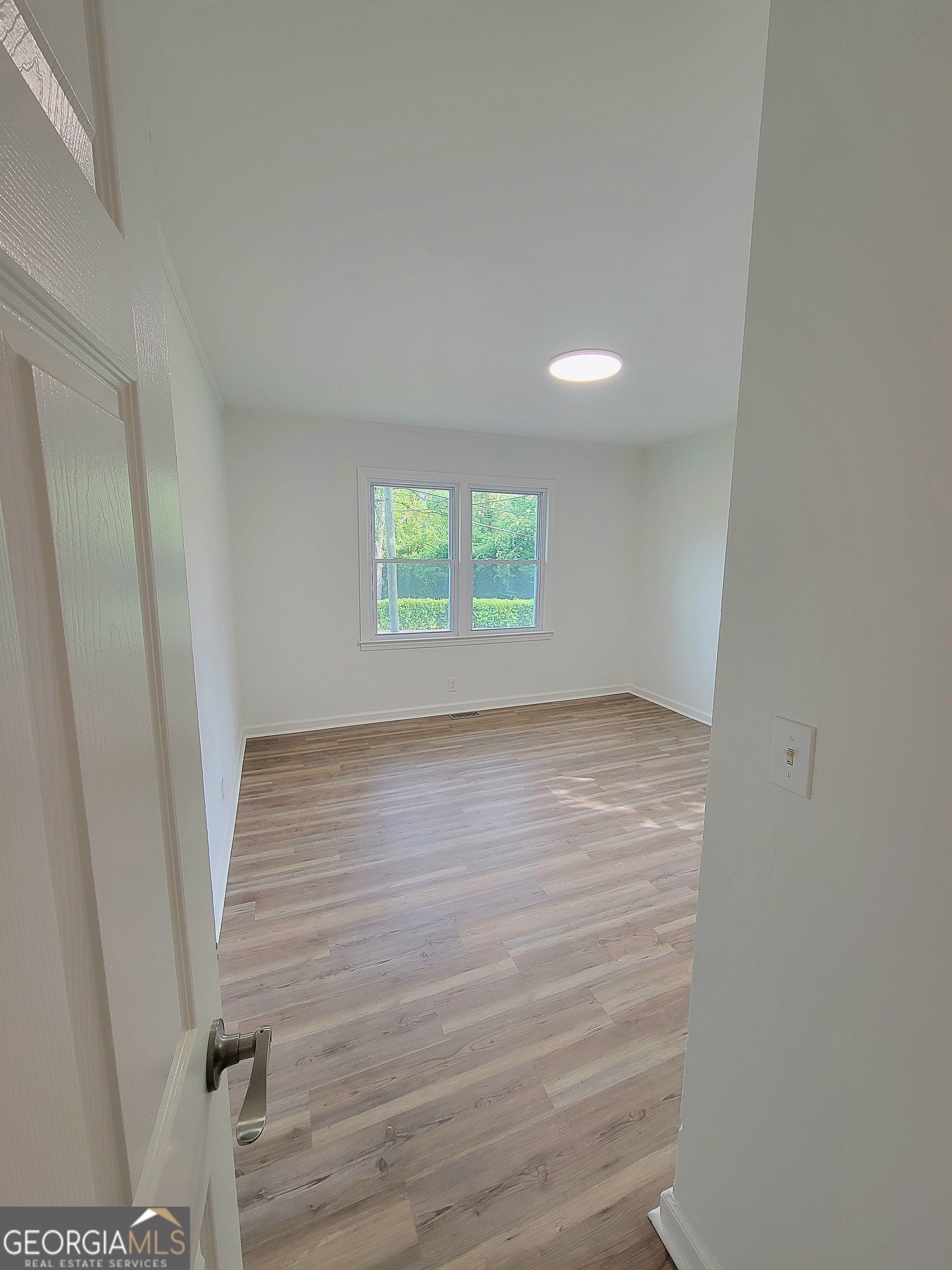 506 East 6th Street West Point, GA 31833 - Photo 10 of 15 an empty room with wooden floor and windows