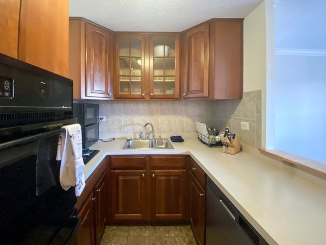 a kitchen with sink a stove and cabinets