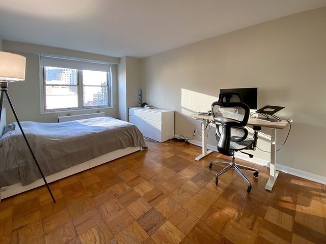 a bedroom with a bed and table chair
