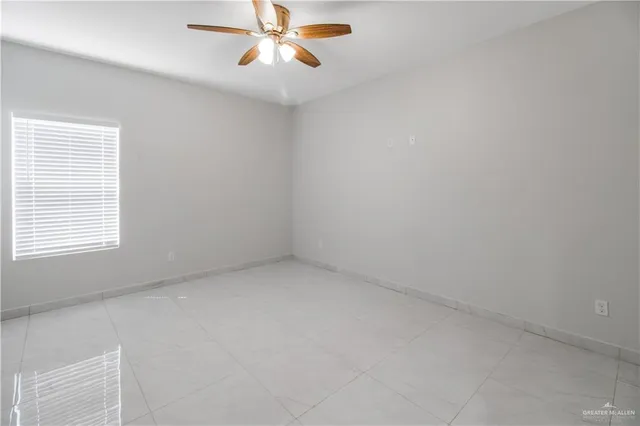 an empty room with a window and a fan