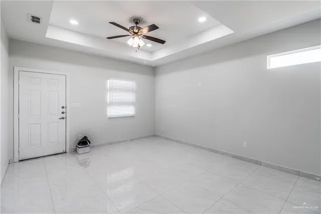 an empty room with windows and fan