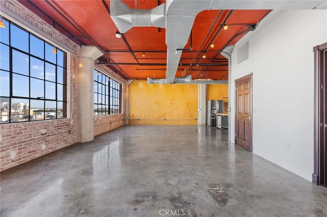 a view of a kitchen with refrigerator and chairs