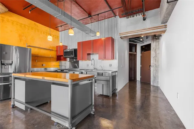 a kitchen with kitchen island a sink stove and refrigerator