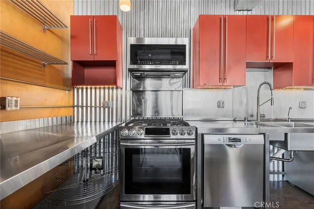 a kitchen with stainless steel appliances granite countertop a sink and a stove