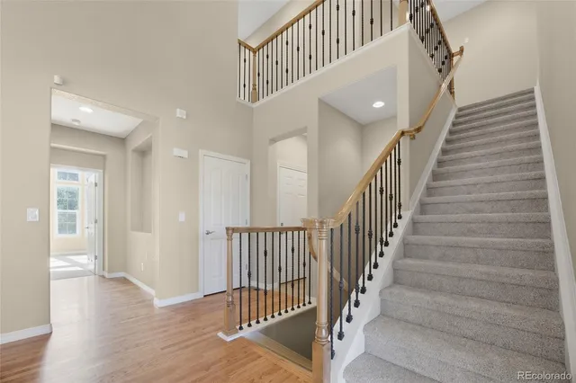 a view of staircase with railing and white walls