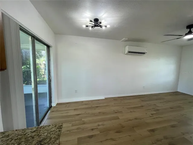 a view of room with hardwood floor and a ceiling fan
