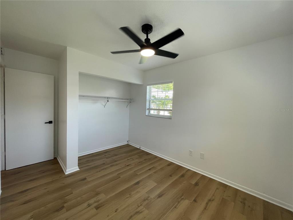 9244 Cyril Court Spring Hill, FL 34608 - Photo 18 of 30 a view of empty room with wooden floor and fan